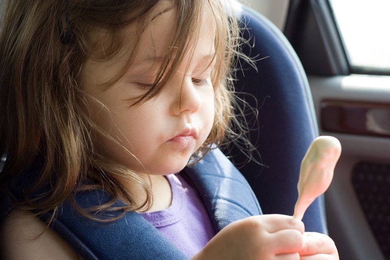 Car seat protector mat installed under infant car seat base protecting leather upholstery